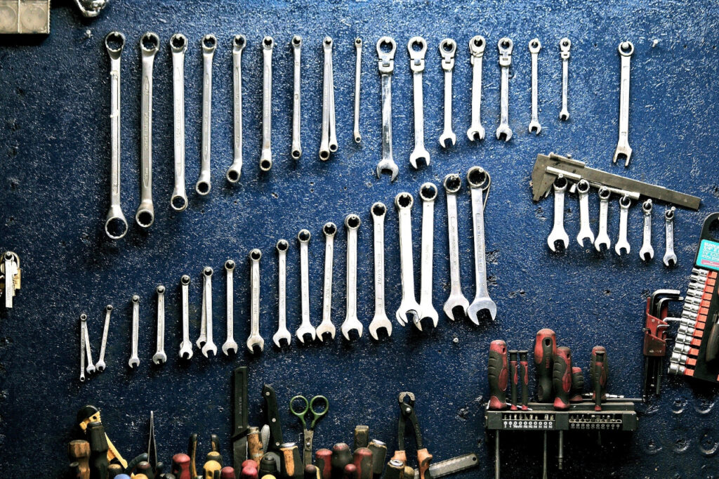 Photo d'outils suspendus  à un mur de couleur bleu